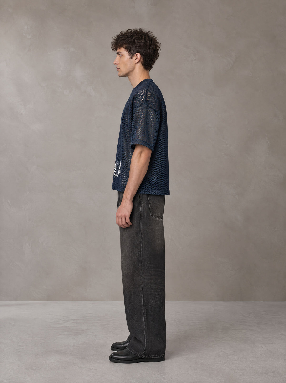 Model wearing the SM Mesh Boxy T-shirt in Oxford Navy, side profile.