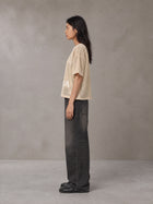 Model wearing the SM Mesh Boxy T-shirt in Soft Beige, side profile.