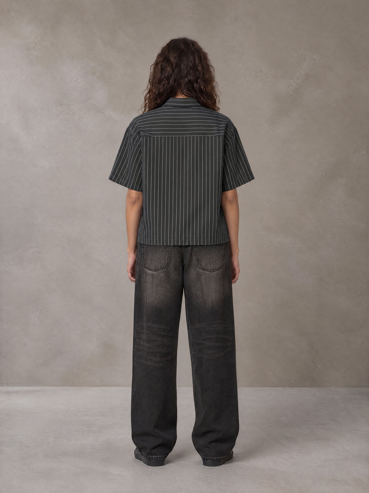 Model wearing the SM Pinstripe Short Sleeve Shirt in Deep Charcoal, rear view.