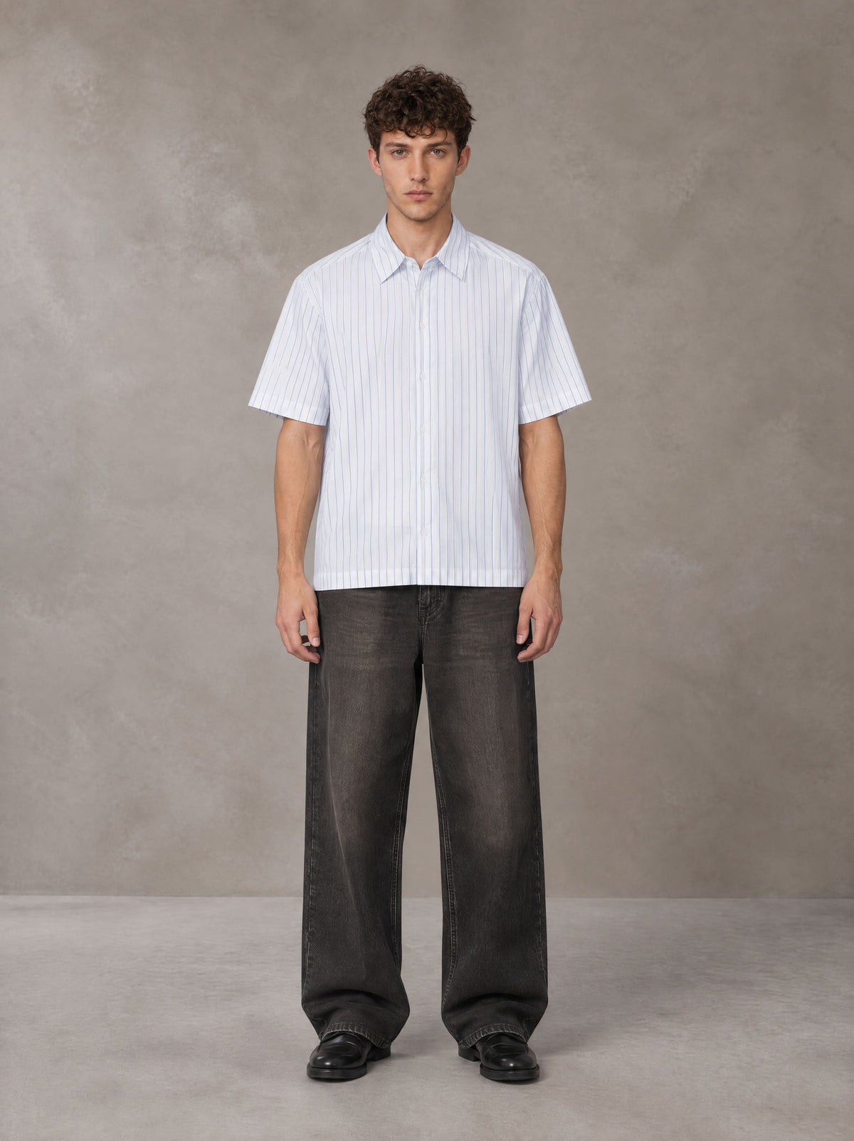 Model wearing the SM Pinstripe Short Sleeve Shirt in Lucent White, front view.