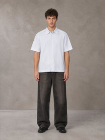 Model wearing the SM Pinstripe Short Sleeve Shirt in Lucent White, front view.