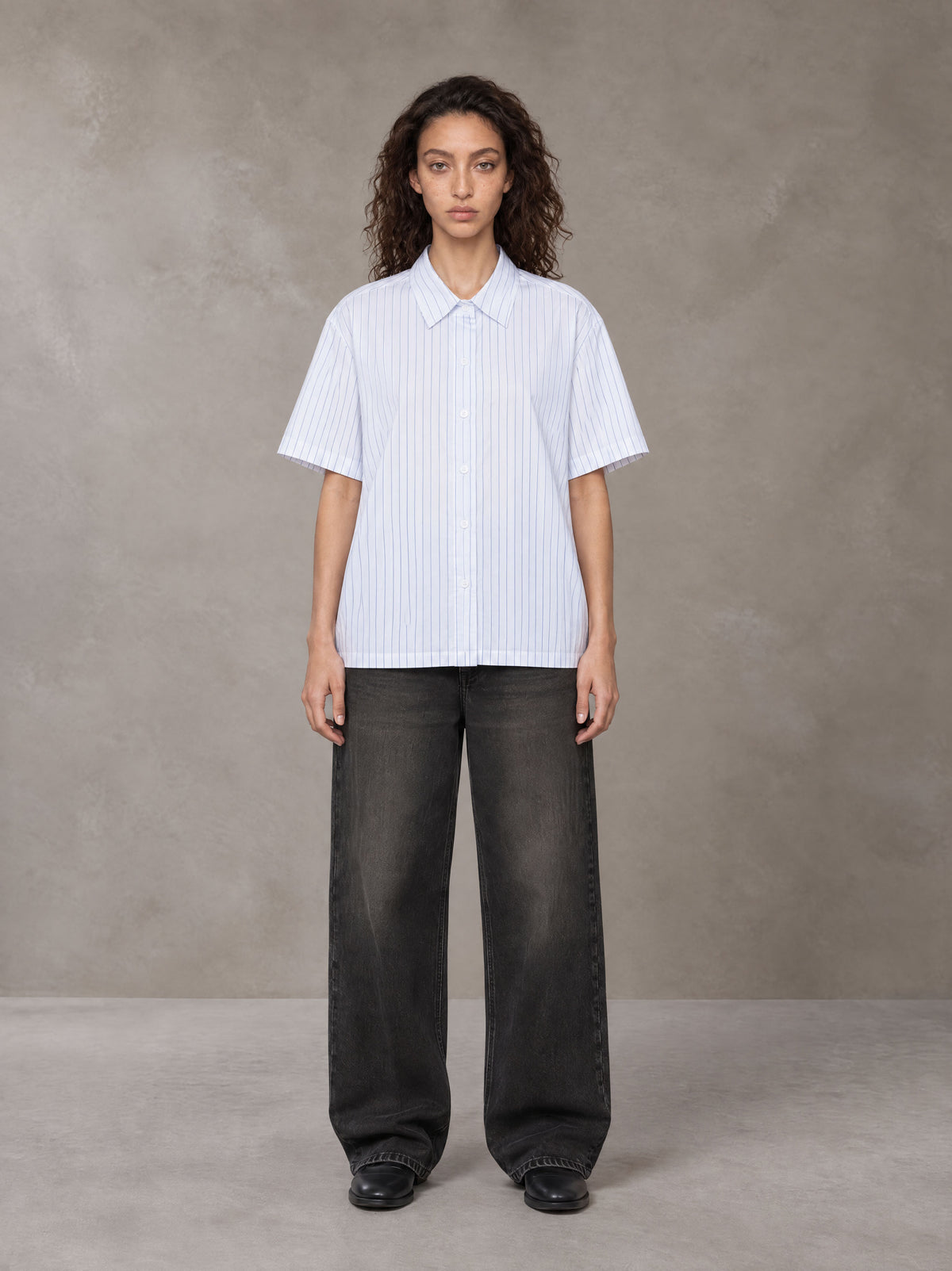 Model wearing the SM Pinstripe Short Sleeve Shirt in Lucent White, front view.