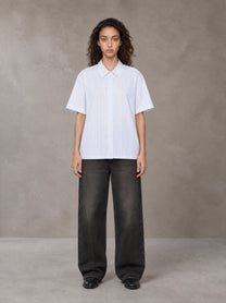 Model wearing the SM Pinstripe Short Sleeve Shirt in Lucent White, front view.