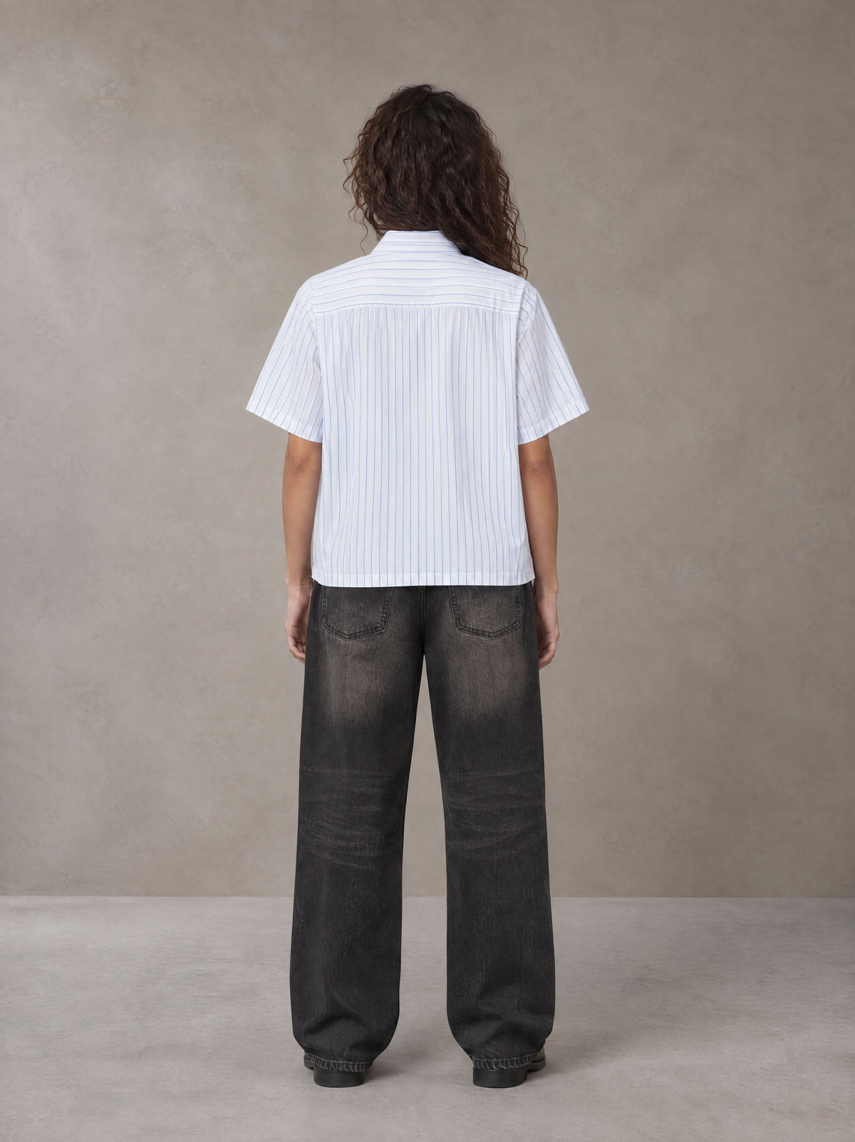 Model wearing the SM Pinstripe Short Sleeve Shirt in Lucent White, rear view.
