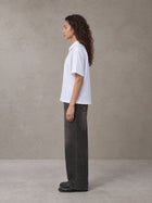 Model wearing the SM Pinstripe Short Sleeve Shirt in Lucent White, side profile.