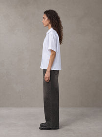 Model wearing the SM Pinstripe Short Sleeve Shirt in Lucent White, side profile.