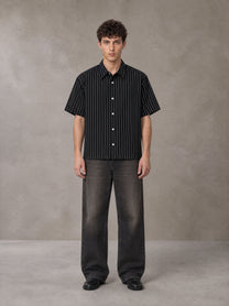 Model wearing the SM Pinstripe Short Sleeve Shirt in Midnight Black, front view.