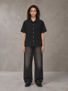 Model wearing the SM Pinstripe Short Sleeve Shirt in Midnight Black, front view.