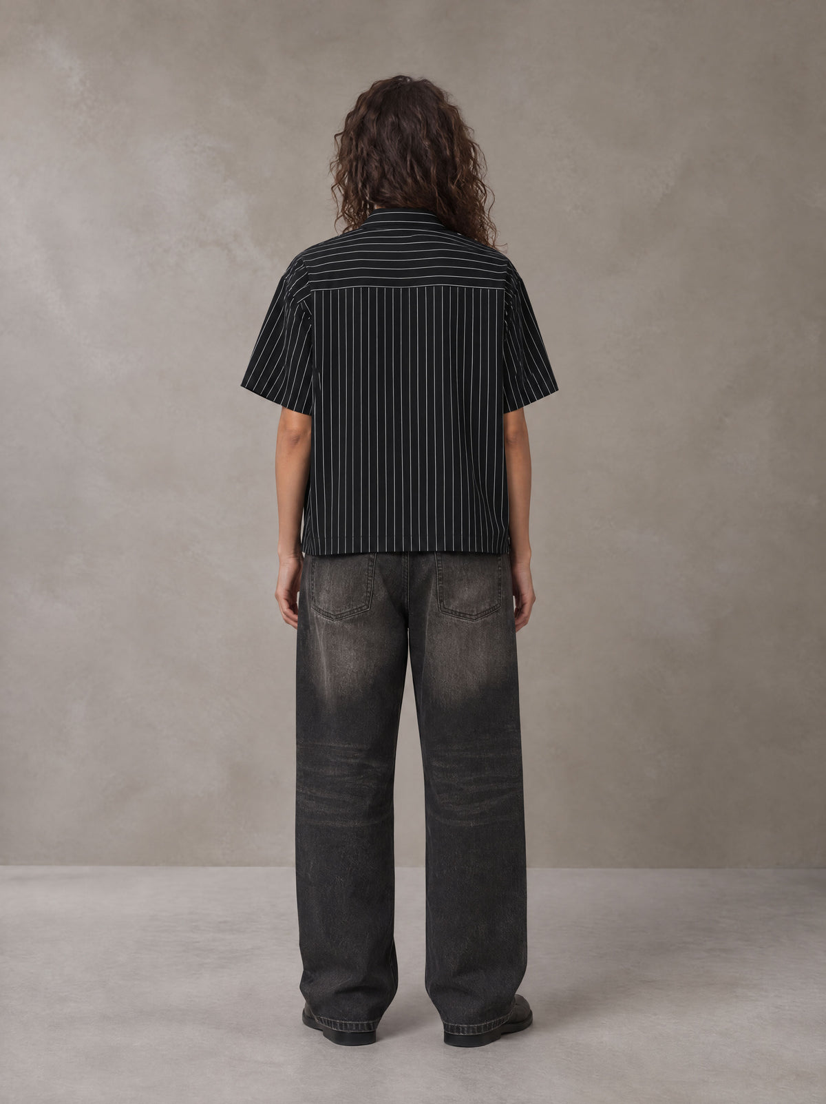 Model wearing the SM Pinstripe Short Sleeve Shirt in Midnight Black, rear view.