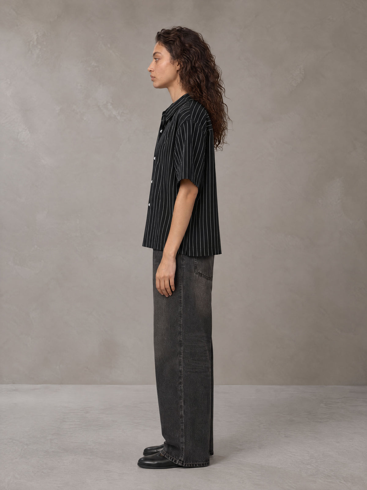 Model wearing the SM Pinstripe Short Sleeve Shirt in Midnight Black, side profile.