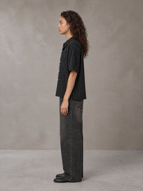 Model wearing the SM Pinstripe Short Sleeve Shirt in Midnight Black, side profile.