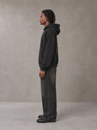 Model wearing the SM Regal Hoodie in Midnight Black, side profile.