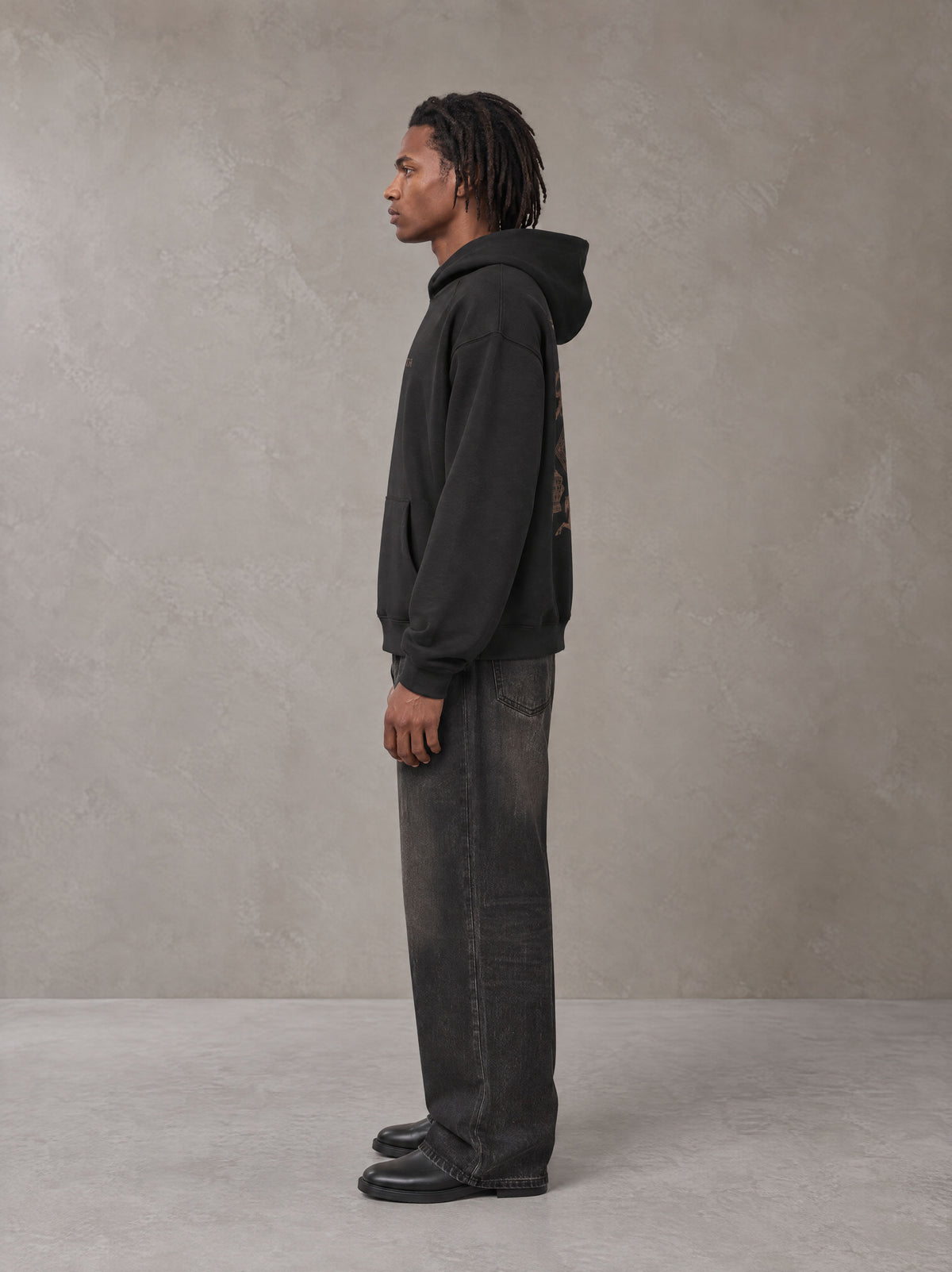 Model wearing the SM Regal Hoodie in Midnight Black, side profile.