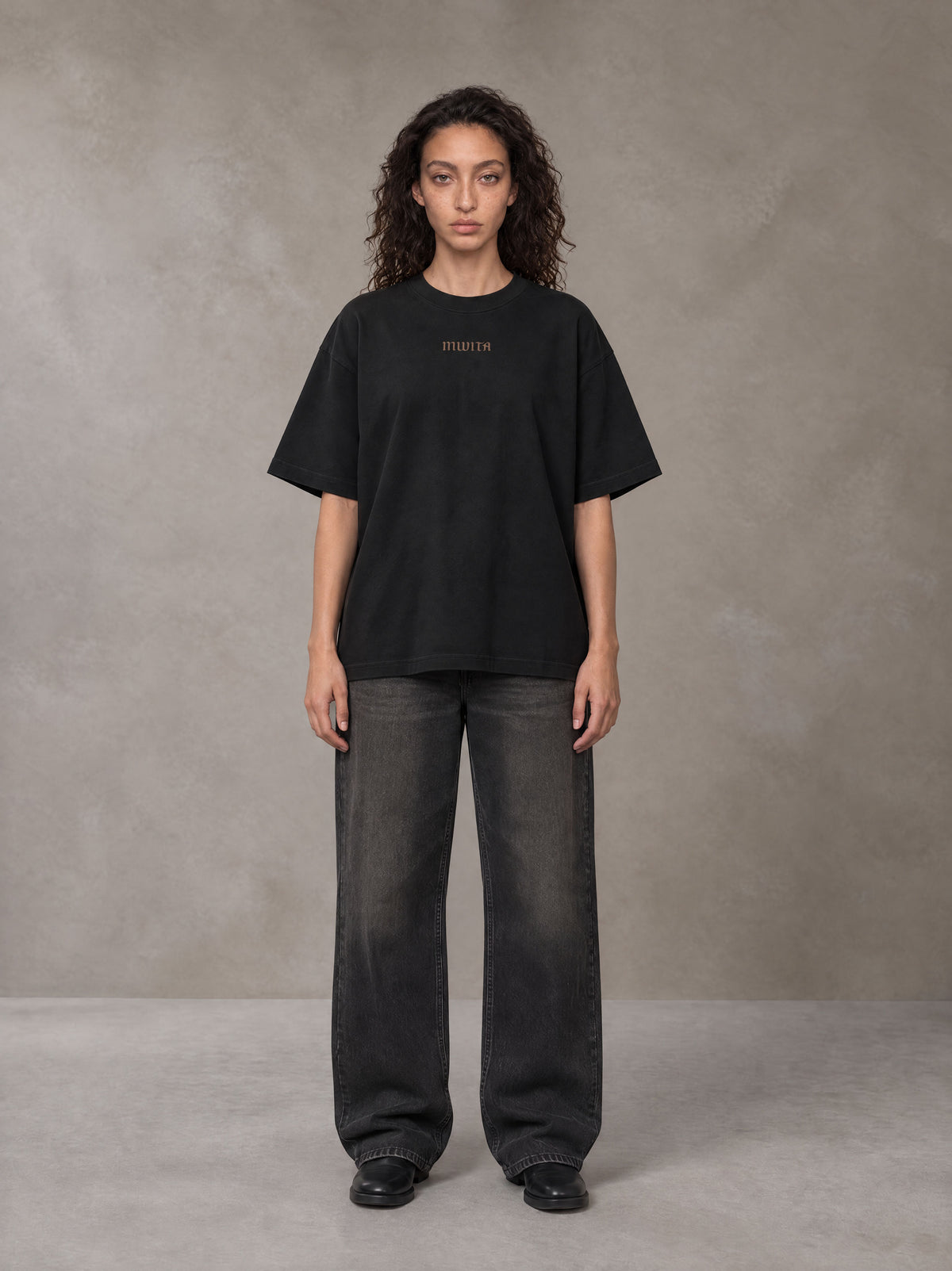 Model wearing the SM Regal T-shirt in Midnight Black, front view.