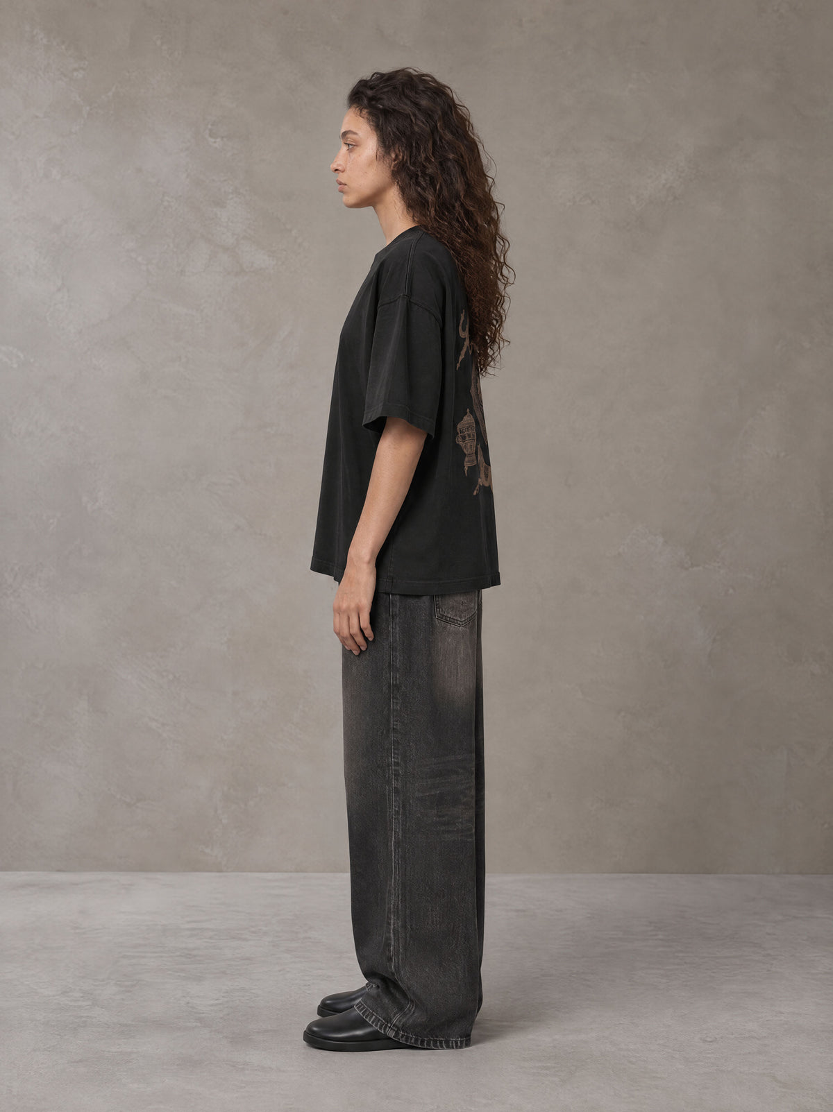 Model wearing the SM Regal T-shirt in Midnight Black, side profile.