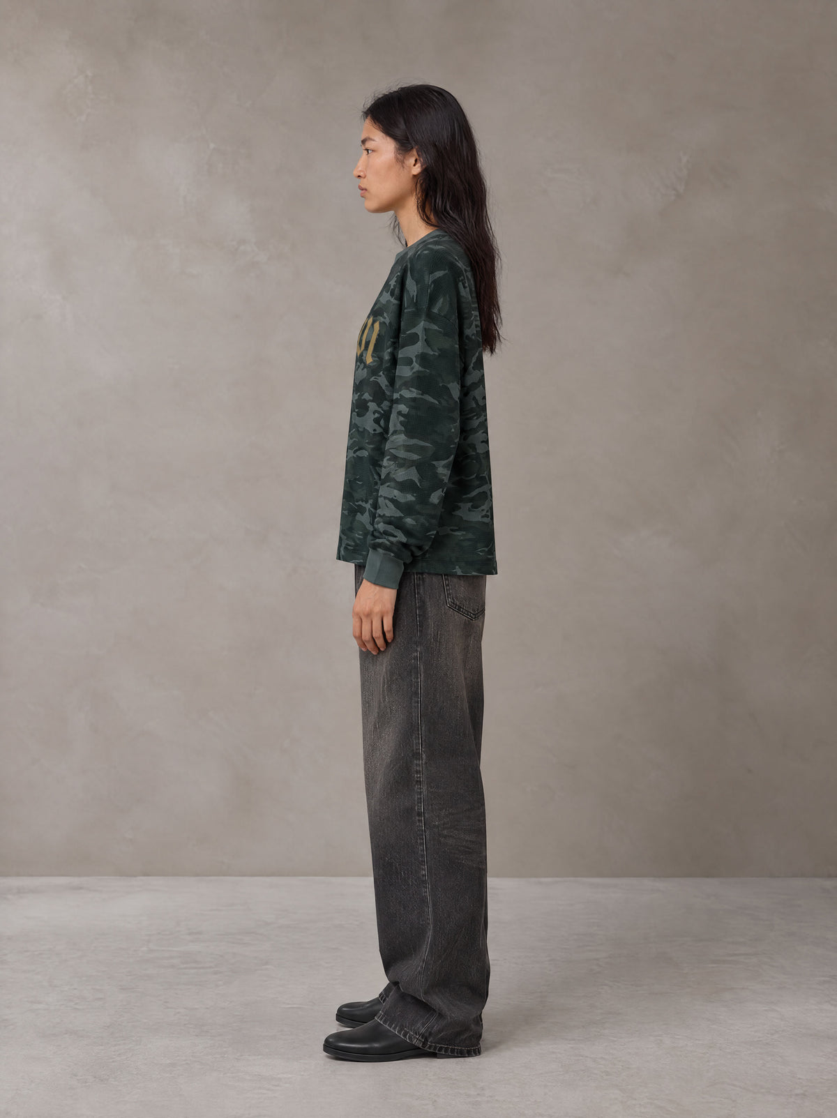 Model wearing the SM Script Camo Long Sleeve T-shirt in Jungle Green, side profile.