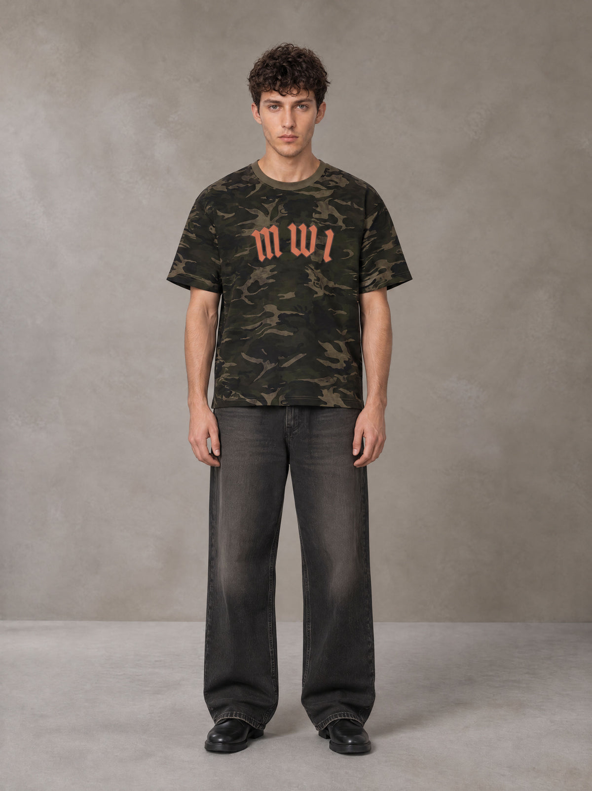 Model wearing the SM Script Camo T-shirt in Rangoon Green, front view.