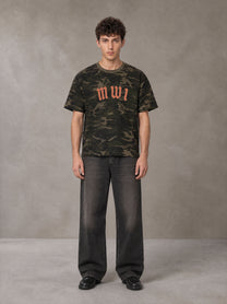 Model wearing the SM Script Camo T-shirt in Rangoon Green, front view.