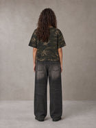 Model wearing the SM Script Camo T-shirt in Rangoon Green, rear view.