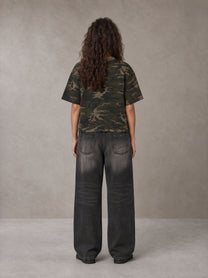 Model wearing the SM Script Camo T-shirt in Rangoon Green, rear view.