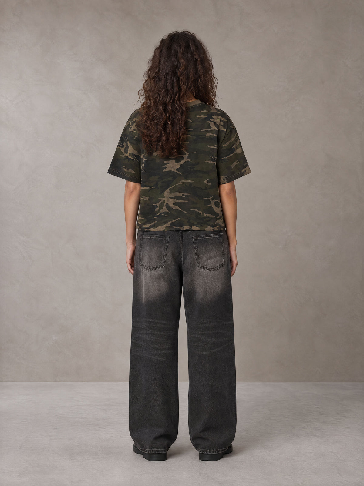 Model wearing the SM Script Camo T-shirt in Rangoon Green, rear view.