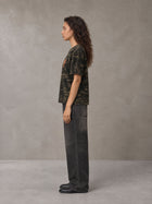 Model wearing the SM Script Camo T-shirt in Rangoon Green, side profile.