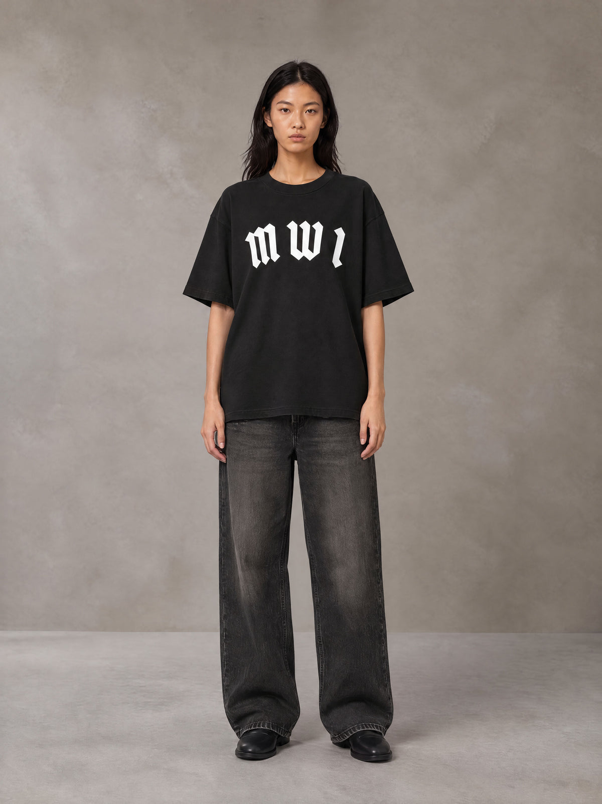 Model wearing the SM Script T-shirt in Midnight Black, front view.