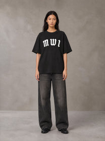 Model wearing the SM Script T-shirt in Midnight Black, front view.