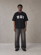 Model wearing the SM Script T-shirt in Midnight Black, front view.