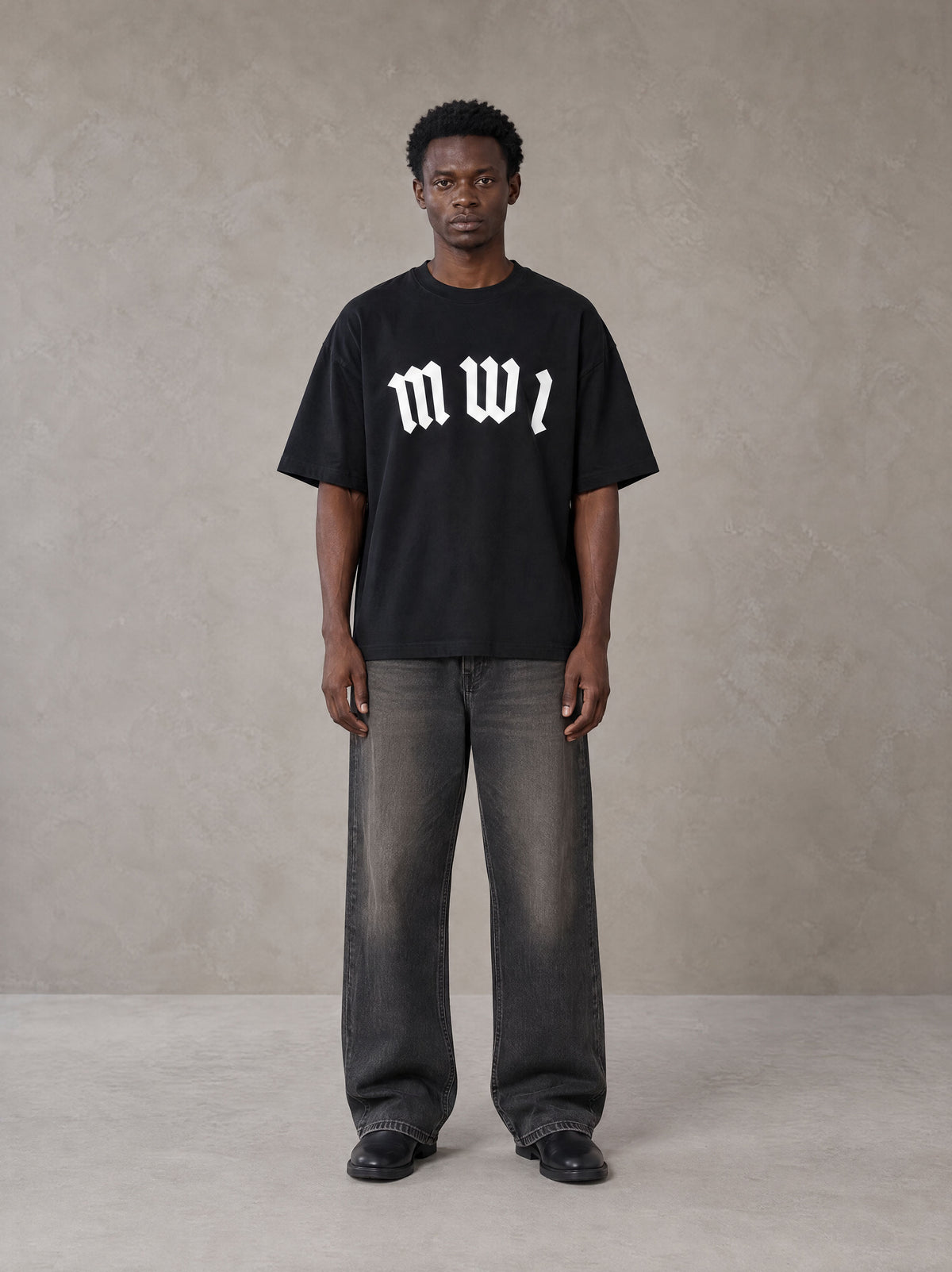 Model wearing the SM Script T-shirt in Midnight Black, front view.