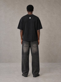 Model wearing the SM Script T-shirt in Midnight Black, rear view.