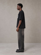 Model wearing the SM Script T-shirt in Midnight Black, side profile.