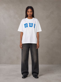 Model wearing the SM Script T-shirt in Lucent White, front view.