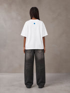 Model wearing the SM Script T-shirt in Lucent White, rear view.