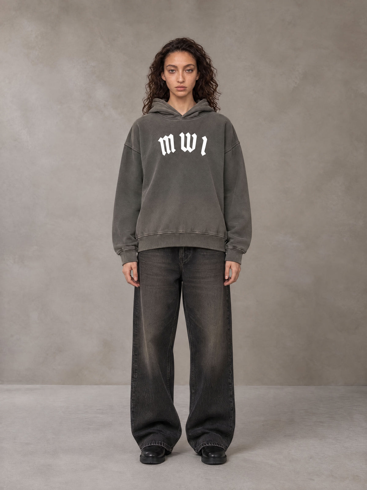 Model wearing the SM Script Washed Hoodie in Ashen Grey, front view.