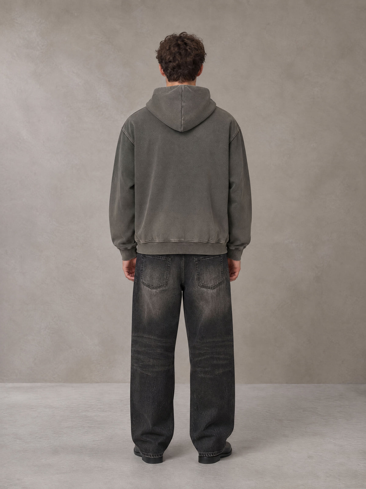 Model wearing the SM Script Washed Hoodie in Ashen Grey, rear view.