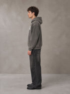 Model wearing the SM Script Washed Hoodie in Ashen Grey, side profile.