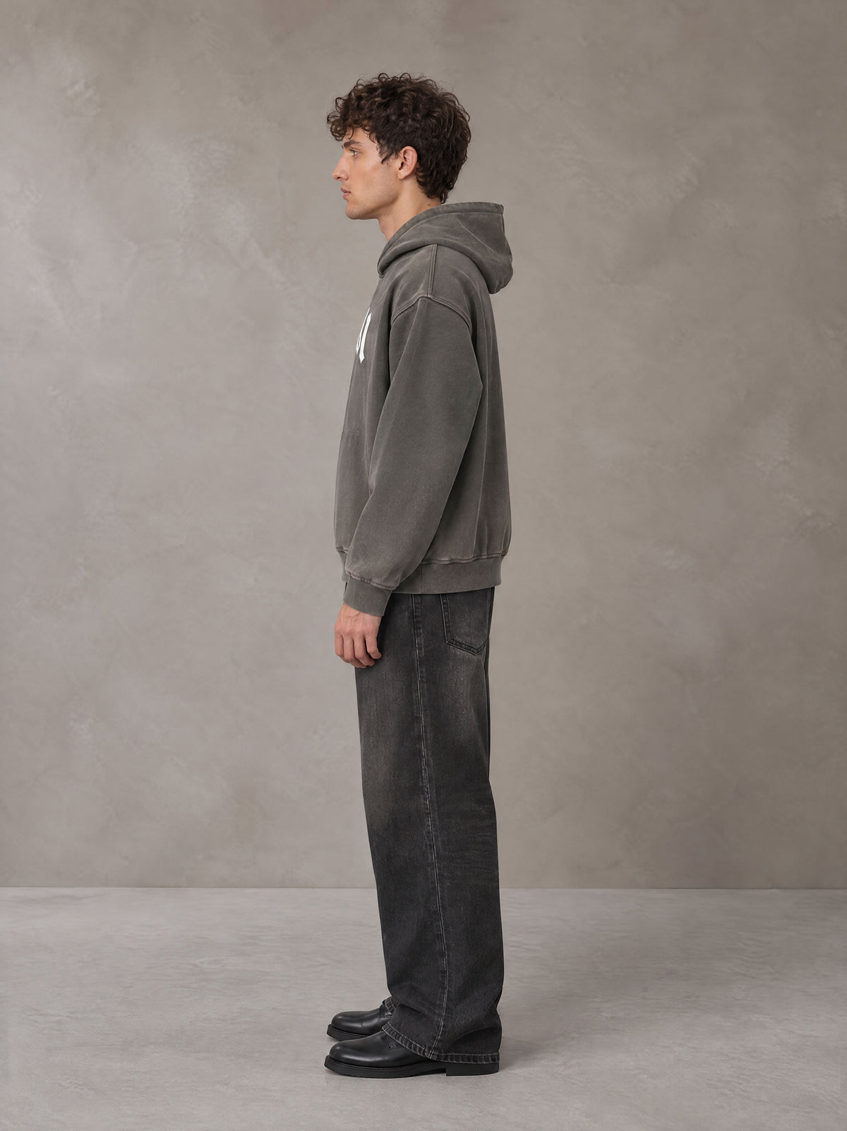 Model wearing the SM Script Washed Hoodie in Ashen Grey, side profile.