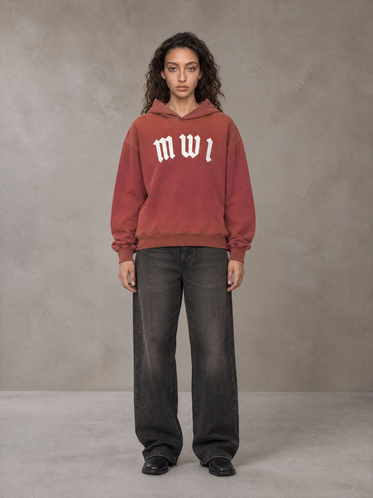 Model wearing the SM Script Washed Hoodie in Copper Rust, front view.