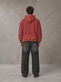 Model wearing the SM Script Washed Hoodie in Copper Rust, rear view.