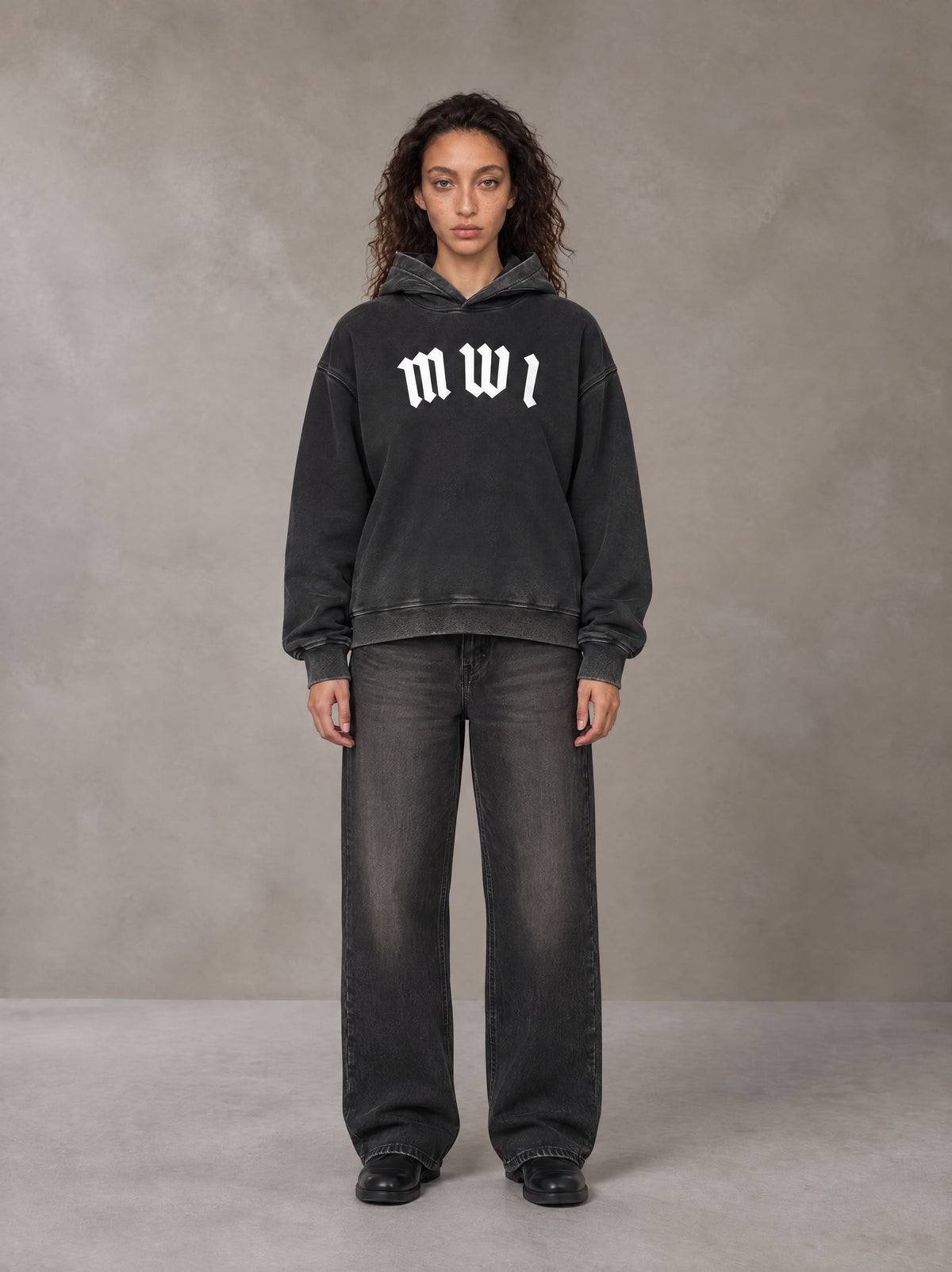 Model wearing the SM Script Washed Hoodie in Midnight Black, front view.