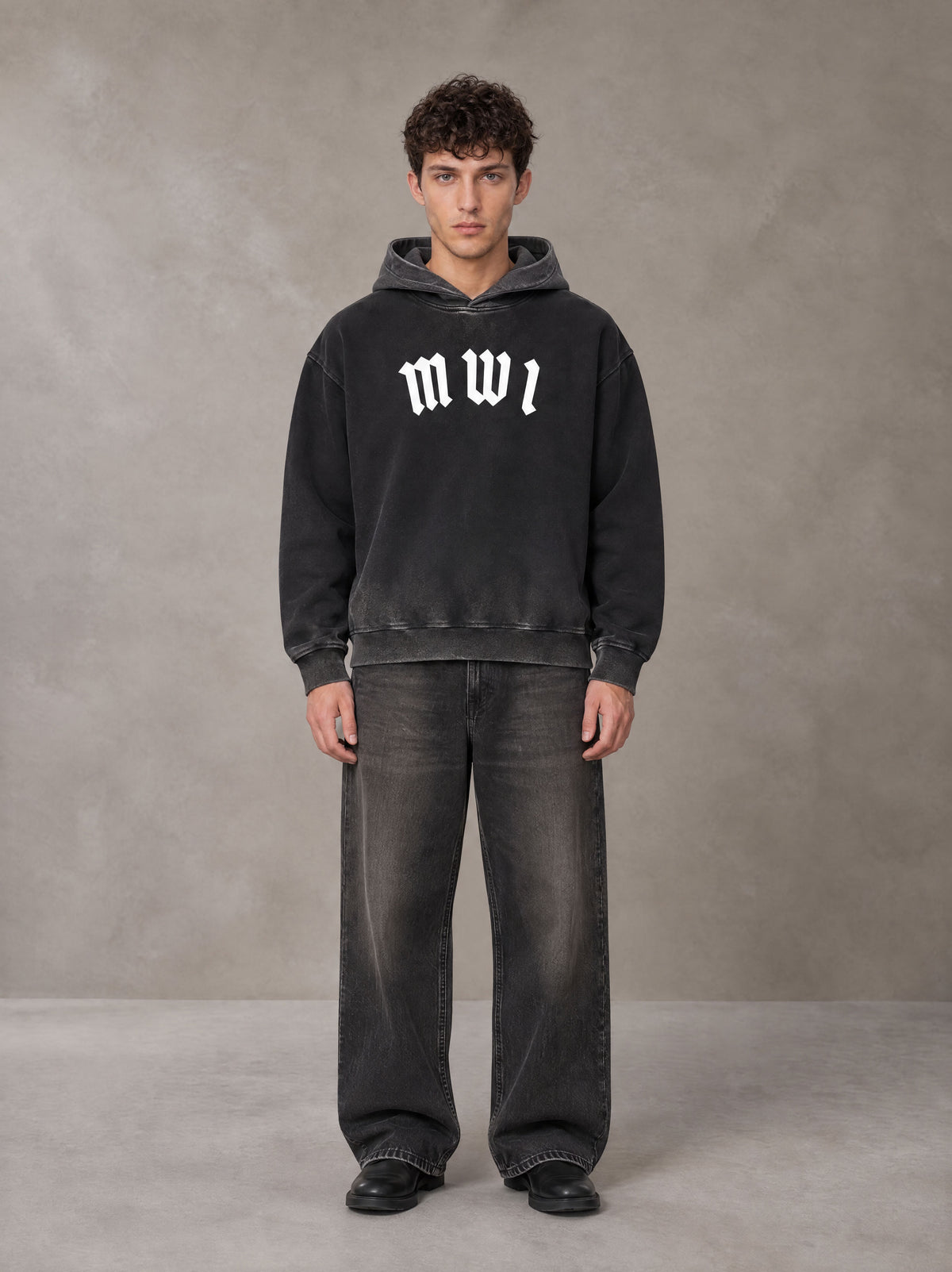 Model wearing the SM Script Washed Hoodie in Midnight Black, front view.