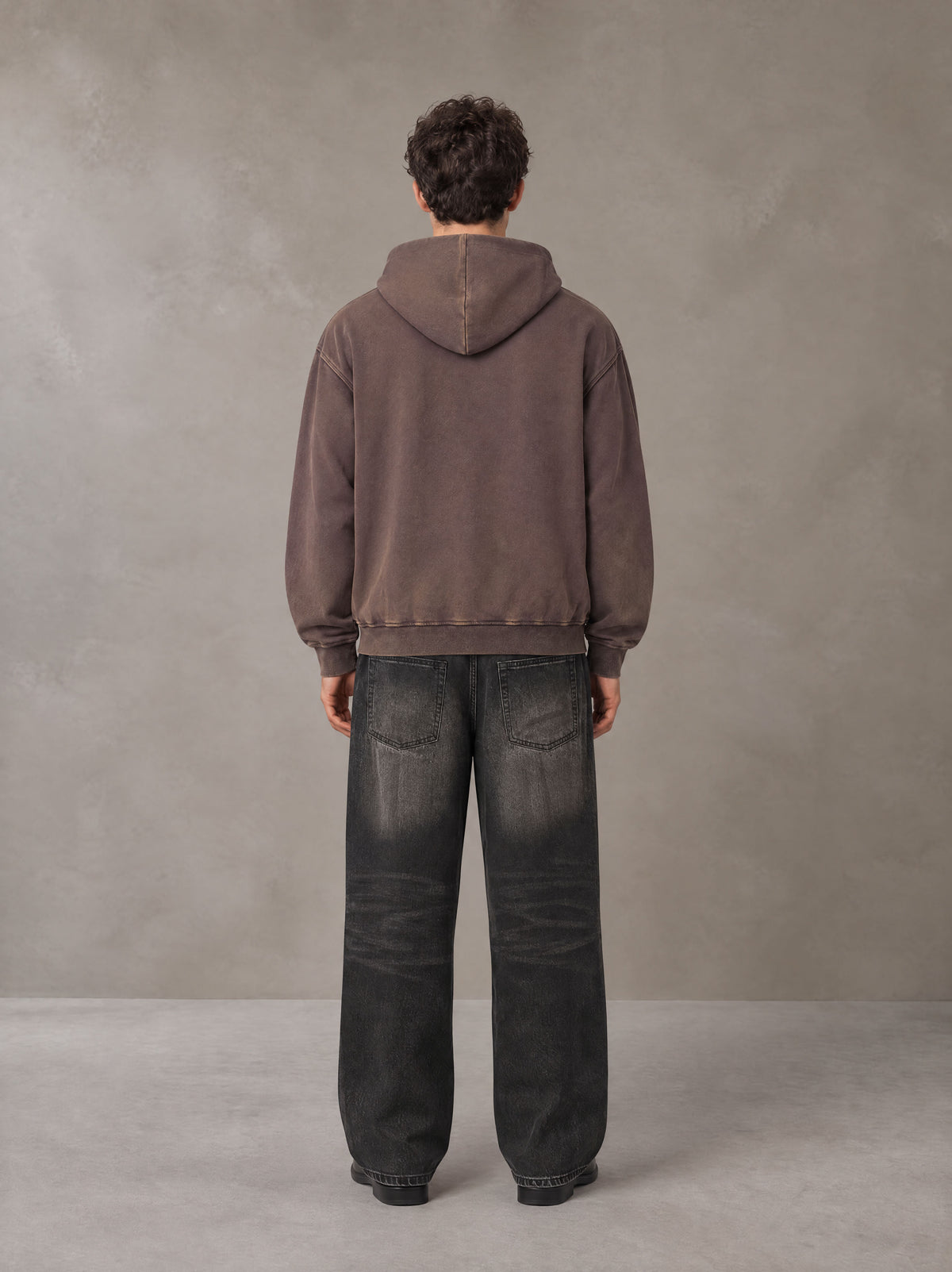 Model wearing the SM Script Washed Hoodie in Soft Taupe, rear view.