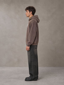 Model wearing the SM Script Washed Hoodie in Soft Taupe, side profile.