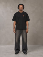Model wearing the SM Sig. Oversized T-shirt in Midnight Black, front view.