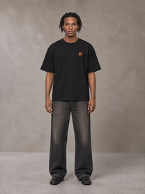 Model wearing the SM Sig. Oversized T-shirt in Midnight Black, front view.