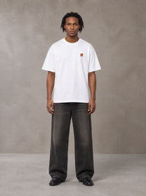 Model wearing the SM Sig. Oversized T-shirt in Lucent White, front view.