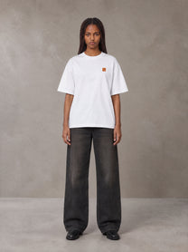 Model wearing the SM Sig. Oversized T-shirt in Lucent White, front view.