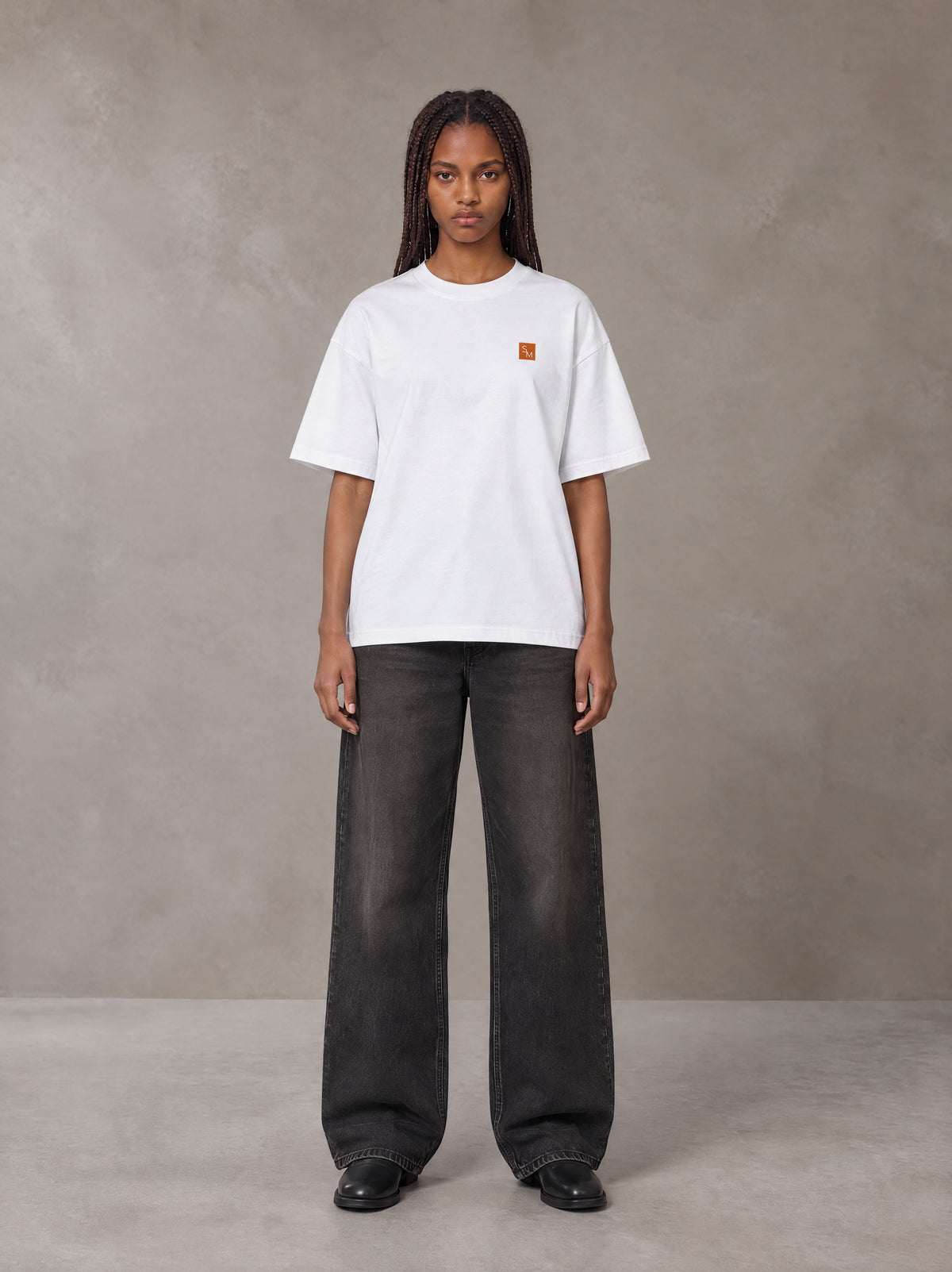 Model wearing the SM Sig. Oversized T-shirt in Lucent White, front view.