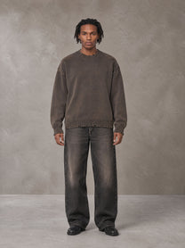 Model wearing the SM Sig. Washed Distress Knit Sweater in Kabul Brown with SM Archive Fade Denim Jeans in black, front view.
